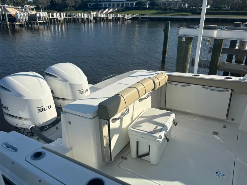 Slide: The Image of 2020 Pursuit DC 295 Dual Console boat with twin Yamaha 300 engines docked by the water. - 13