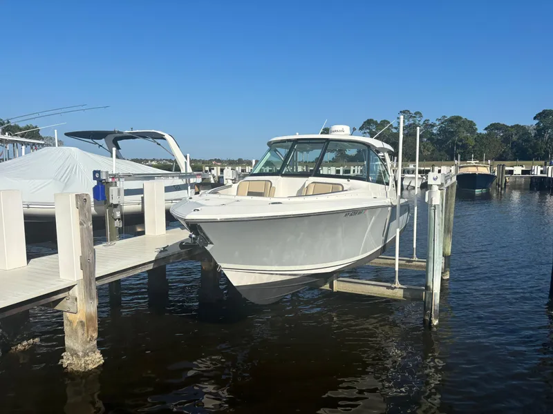 Slide: The Image of 2020 Pursuit DC 295 Dual Console boat docked at marina. - 2