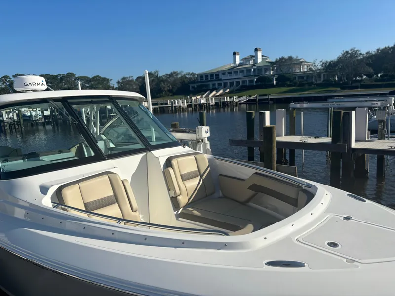 Slide: The Image of 2020 Pursuit DC 295 Dual Console boat docked near a waterfront property. - 4