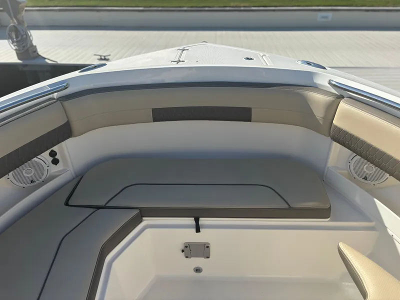 Slide: The Image of 2020 Pursuit DC 295 Dual Console boat interior with cushioned seating and speakers. - 5