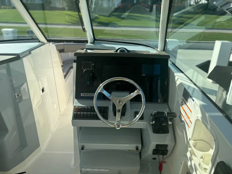 Slide: The Image of 2020 Pursuit DC 295 Dual Console boat interior with steering wheel and control panel. - 7