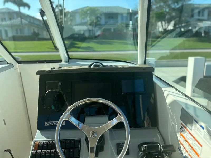 Slide: The Image of 2020 Pursuit DC 295 Dual Console boat dashboard with steering wheel and controls. - 8