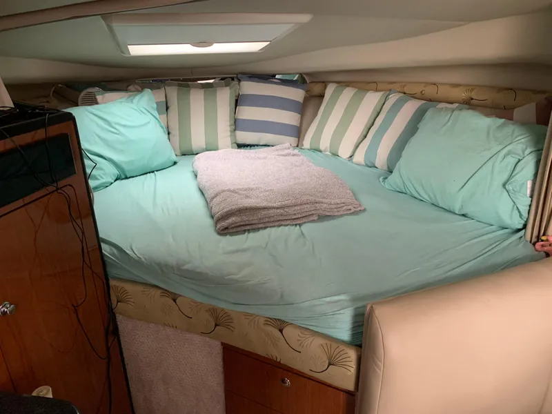 Slide: The Image of Cozy cabin interior of 2000 Chaparral Signature 300 with striped pillows and teal bedding. - 6