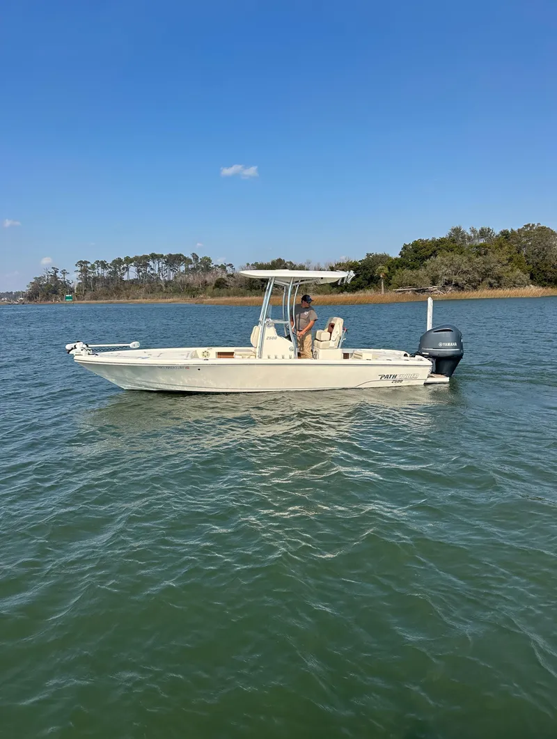 Slide: The Image of 2020 Pathfinder 2500 Hybrid boat on calm water with scenic background. - 18