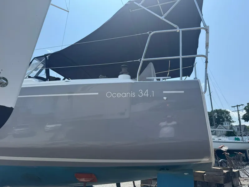 Slide: The Image of 2024 Beneteau Oceanis 34.1 sailboat with dark canopy, docked outdoors. - 25