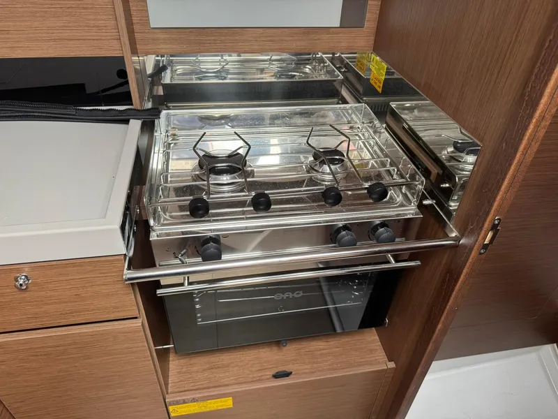 Slide: The Image of 2024 Beneteau Oceanis 34.1 cabin interior with cozy white bedding and wooden accents. - 8