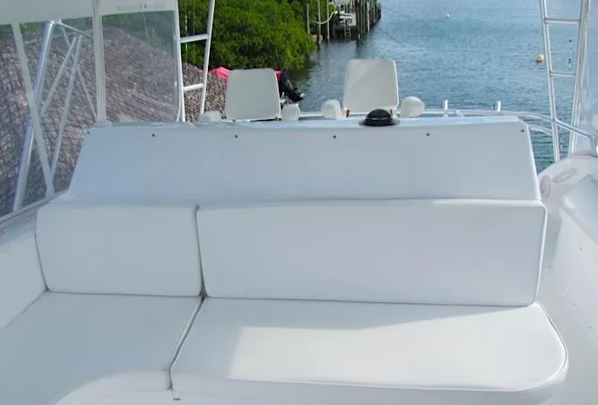 Slide: The Image of 1999 Viking Boats Convertible with white seating, docked by a scenic waterfront. - 10