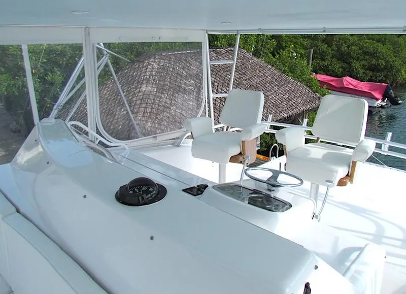 Slide: The Image of 1999 Viking Boats Convertible yacht helm with white captain chairs and navigation equipment. - 11