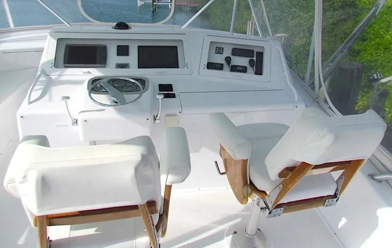 Slide: The Image of 1999 Viking Boats Convertible helm with dual white captain chairs and control panel. - 12