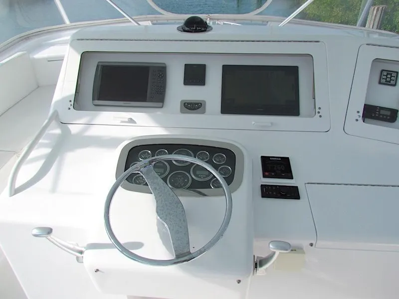 Slide: The Image of 1999 Viking Boats Convertible helm with steering wheel and navigation controls. - 16