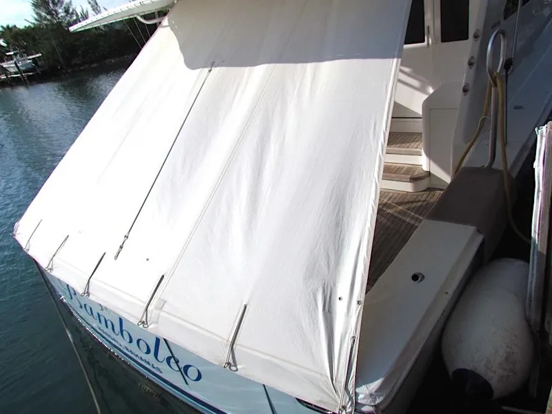 Slide: The Image of 1999 Viking Boats Convertible with white canopy docked by the water. - 18