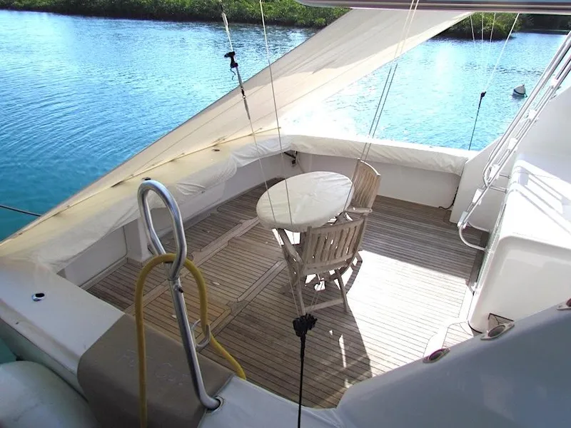 Slide: The Image of 1999 Viking Boats Convertible yacht deck with table and chairs, overlooking serene water. - 19