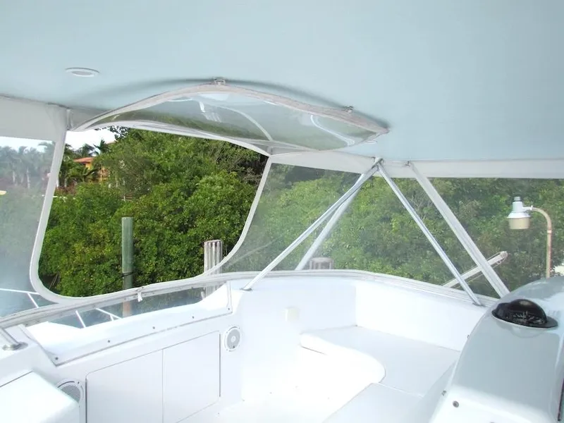 Slide: The Image of 1999 Viking Boats Convertible interior with clear canopy and lush greenery view. - 20