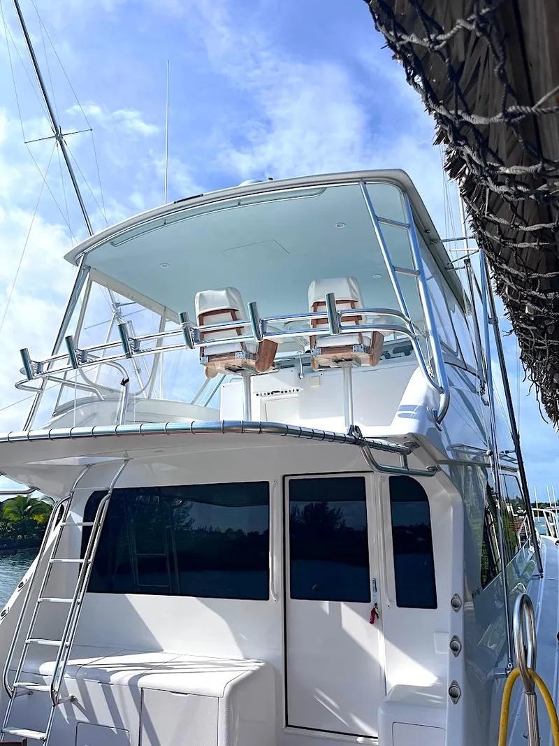 Slide: The Image of 1999 Viking Boats Convertible yacht docked, featuring a spacious upper deck and sleek design. - 21