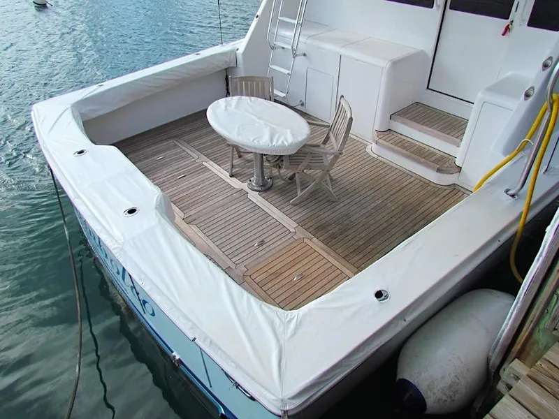 Slide: The Image of 1999 Viking Boats Convertible with wooden deck and seating area by the water. - 22