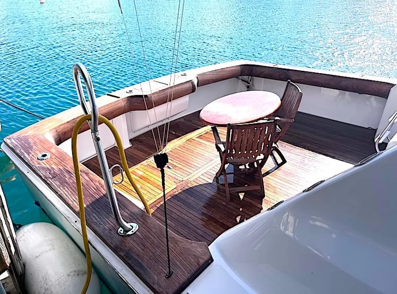 Slide: The Image of 1999 Viking Boats Convertible deck with wooden table and chairs, overlooking blue water. - 24