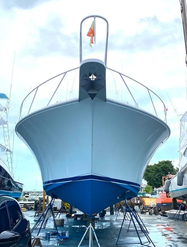 Slide: The Image of 1999 Viking Boats Convertible on stands, viewed from the front in a boatyard. - 26