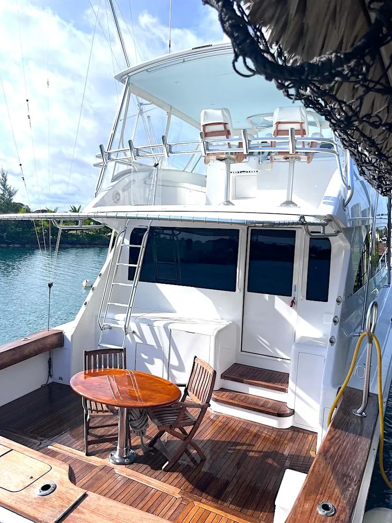 Slide: The Image of 1999 Viking Boats Convertible yacht with wooden deck and seating area, docked by the water. - 27