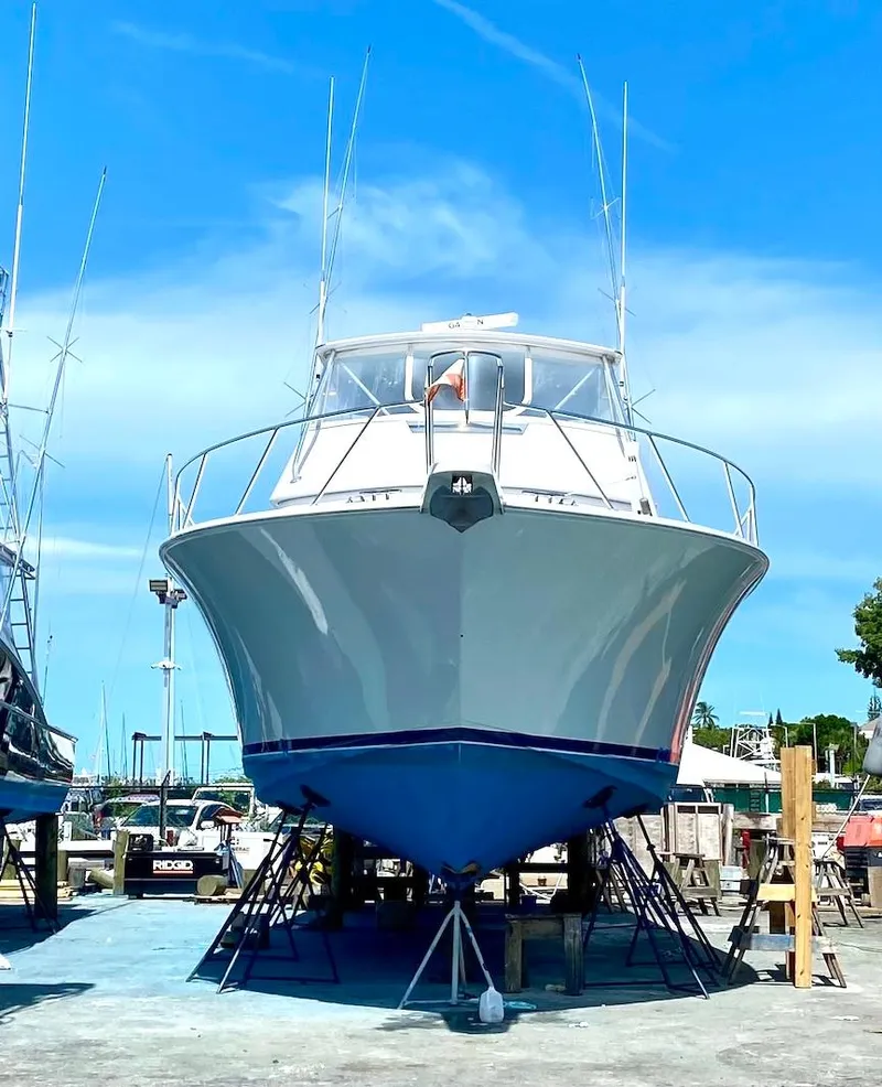 Slide: The Image of 1999 Viking Boats Convertible on dry dock under clear blue sky. - 28