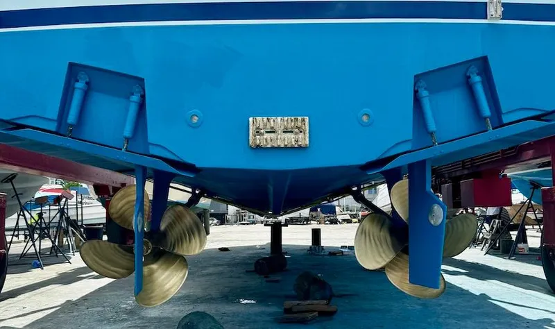 Slide: The Image of 1999 Viking Boats Convertible with dual propellers in dry dock, showcasing blue hull. - 29