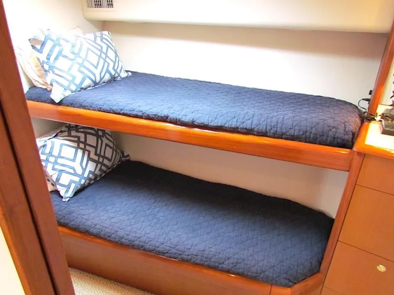 Slide: The Image of Bunk beds with blue bedding in a 1999 Viking Convertible boat cabin. - 34