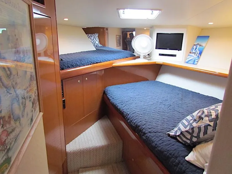 Slide: The Image of 1999 Viking Convertible boat cabin with twin beds, TV, and wooden interior. - 35