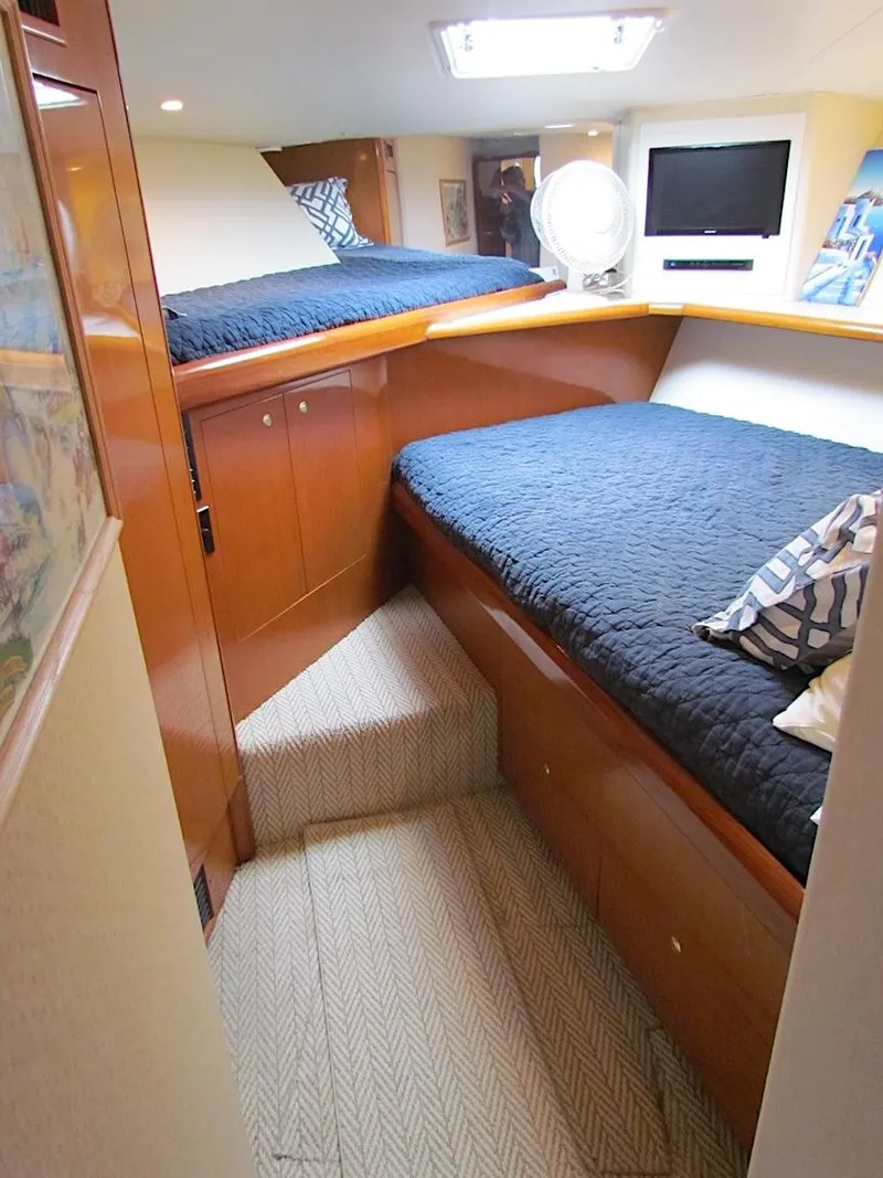 Slide: The Image of 1999 Viking Boats Convertible cabin interior with twin beds, wood finish, and modern amenities. - 37