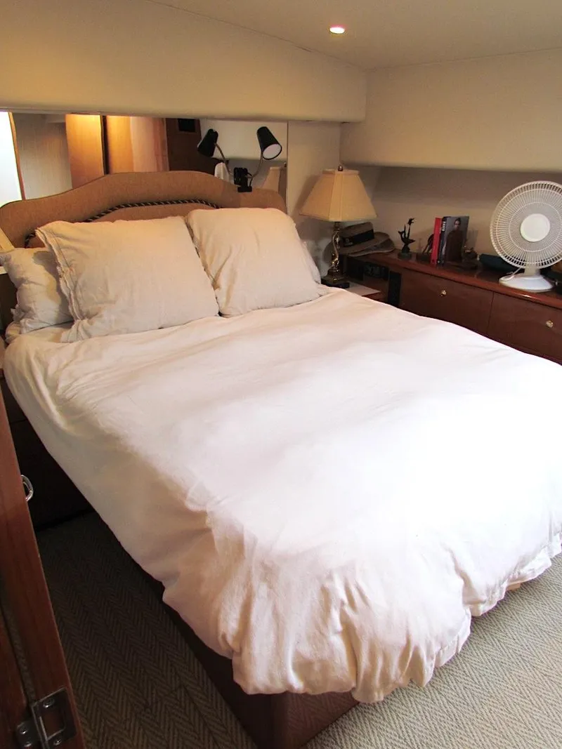 Slide: The Image of 1999 Viking Boats Convertible bedroom with cozy bed, lamps, and fan. - 39