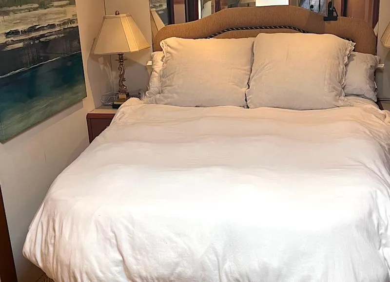 Slide: The Image of Cozy bedroom interior on 1999 Viking Boats Convertible, featuring a plush bed and elegant decor. - 40