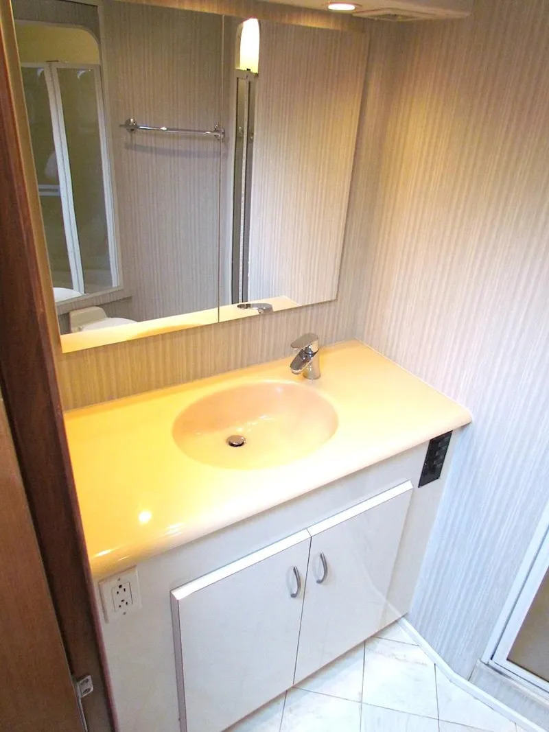 Slide: The Image of Bathroom vanity in a 1999 Viking Boats Convertible, featuring a sleek countertop and mirror. - 42