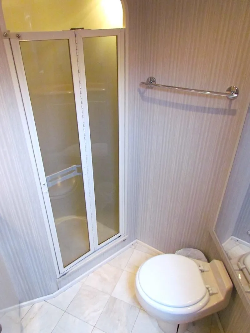 Slide: The Image of 1999 Viking Boats Convertible bathroom with shower, toilet, and towel rack. - 43