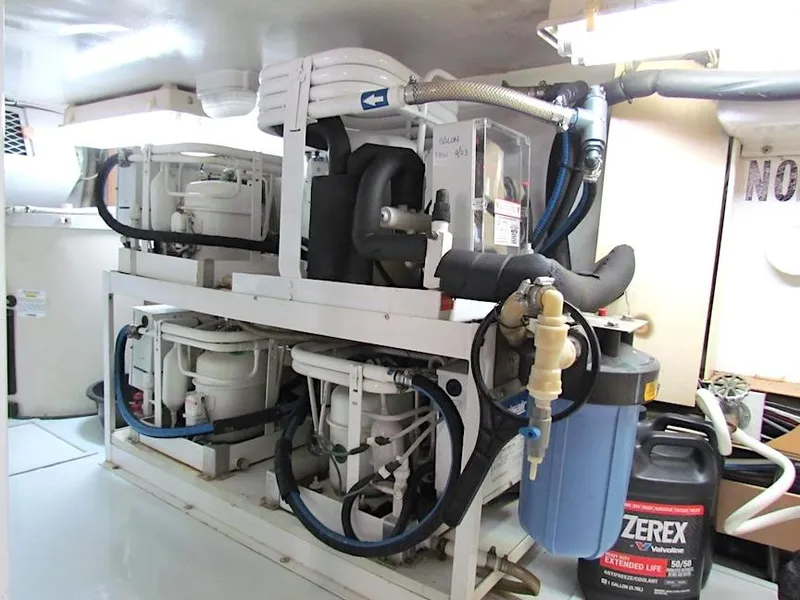 Slide: The Image of Engine room of a 1999 Viking Boats Convertible, featuring mechanical components and Zerex coolant. - 48