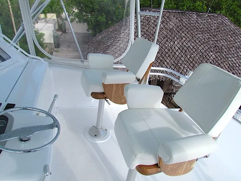 Slide: The Image of 1999 Viking Boats Convertible helm with white captain chairs and steering wheel. - 9