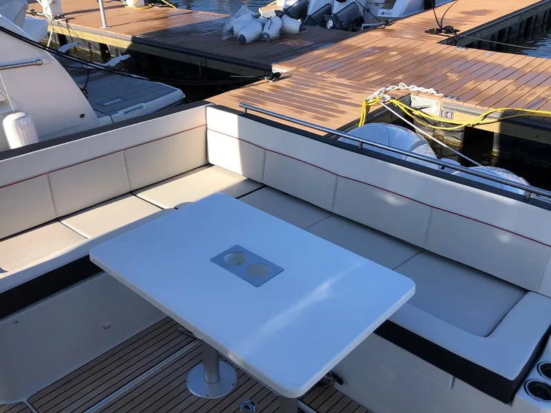 Slide: The Image of 2024 Jeanneau Leader 12.5 WA boat with spacious seating and table at dock. - 5