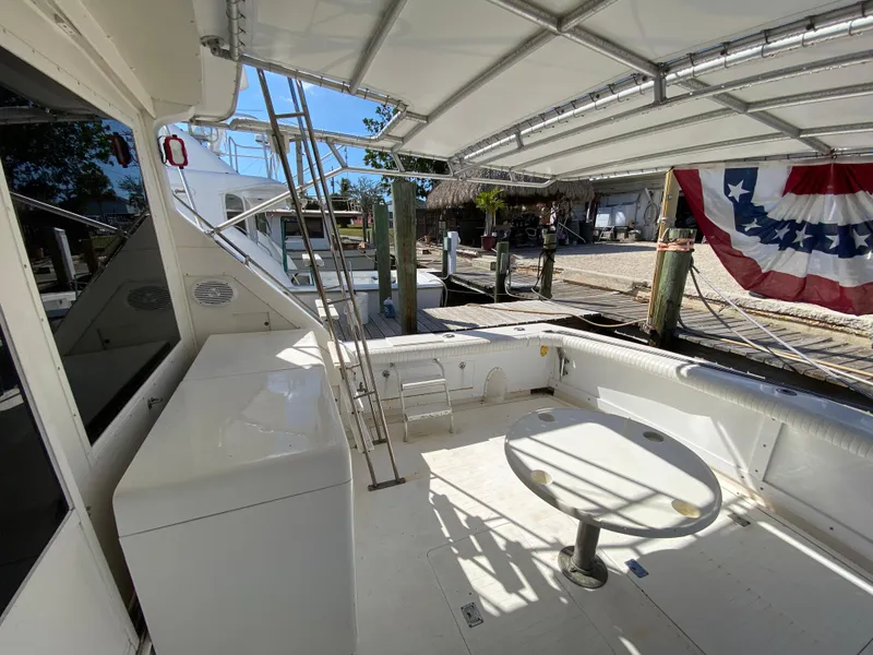 Slide: The Image of 1982 Bertram 46.6 War Wagon yacht deck with seating and American flag. - 13