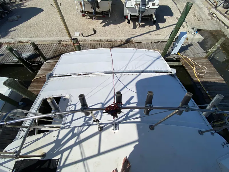 Slide: The Image of 1982 Bertram 46.6 War Wagon boat docked, viewed from above, showing deck and fishing rod holders. - 16