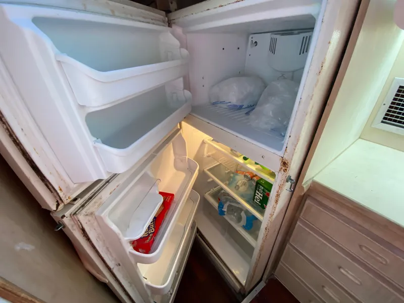 Slide: The Image of Open refrigerator on 1982 Bertram 46.6 War Wagon, showing freezer and fridge compartments. - 25