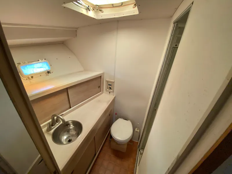 Slide: The Image of 1982 Bertram 46.6 War Wagon bathroom with sink, toilet, and porthole window. - 28