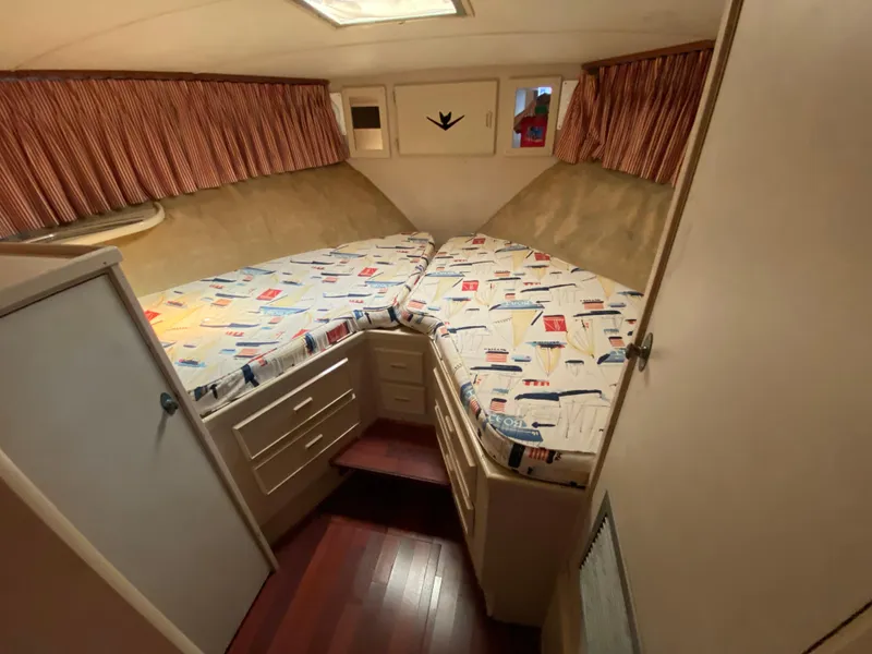 Slide: The Image of 1982 Bertram 46.6 War Wagon cabin interior with twin beds and nautical-themed bedding. - 35