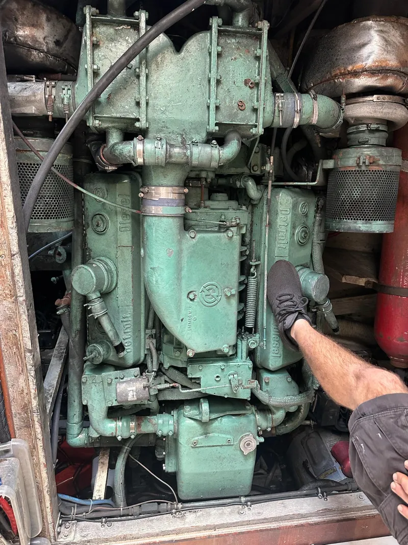 Slide: The Image of Engine of 1982 Bertram 46.6 War Wagon boat, with visible mechanical components and a person's leg. - 49