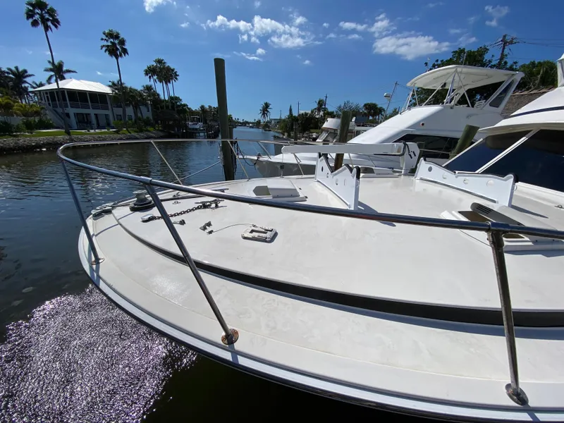 Slide: The Image of 1982 Bertram 46.6 War Wagon yacht docked in sunny marina with palm trees. - 5