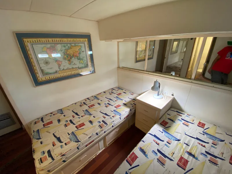 Slide: The Image of Interior of 1982 Bertram 46.6 War Wagon with twin beds and nautical-themed decor. - 30