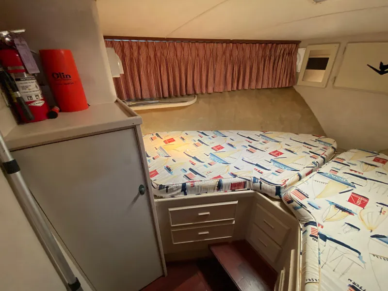 Slide: The Image of Cozy cabin interior of 1982 Bertram 46.6 War Wagon with nautical-themed bedding. - 36