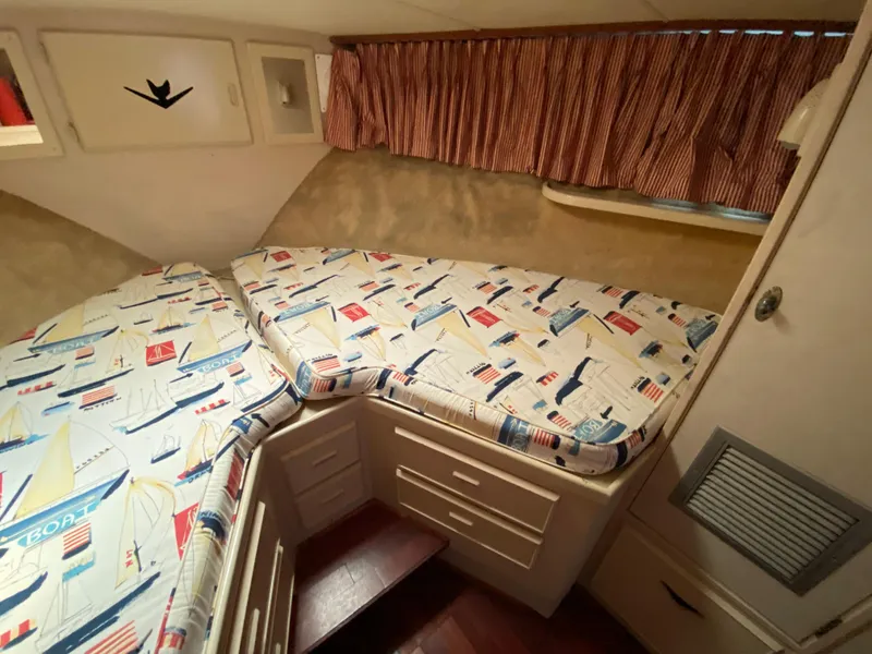 Slide: The Image of Cozy cabin interior of 1982 Bertram 46.6 War Wagon with nautical-themed bedding. - 37