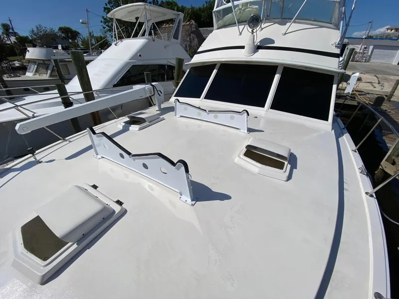 Slide: The Image of 1982 Bertram 46.6 War Wagon yacht docked, showcasing spacious deck and sleek design. - 9