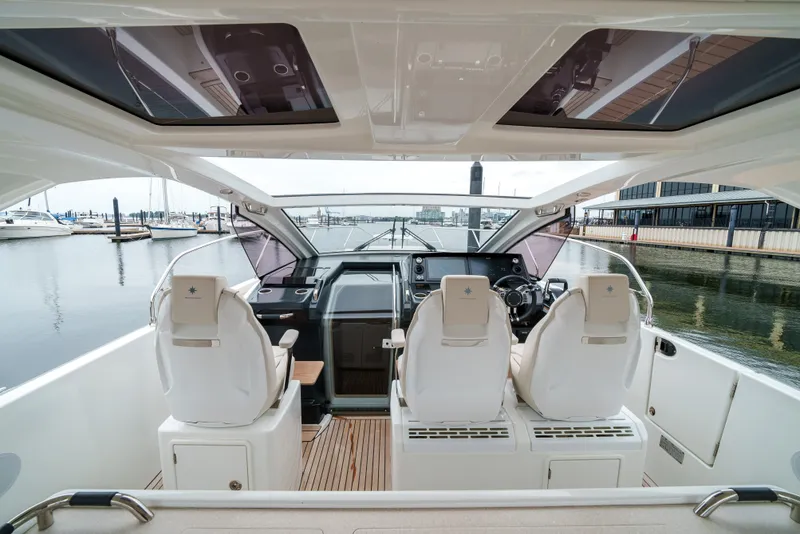 Slide: The Image of 2024 Jeanneau DB/43 OB boat interior with modern helm and seating at marina. - 21