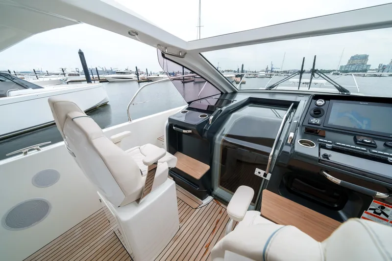 Slide: The Image of 2024 Jeanneau DB/43 OB boat interior with modern helm and seating at marina. - 35