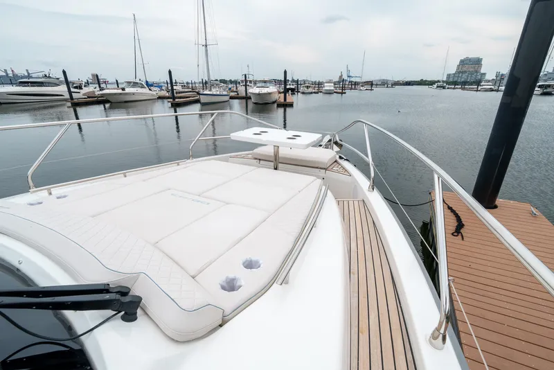 Slide: The Image of 2024 Jeanneau DB/43 OB yacht docked at marina, featuring spacious deck and sleek design. - 40