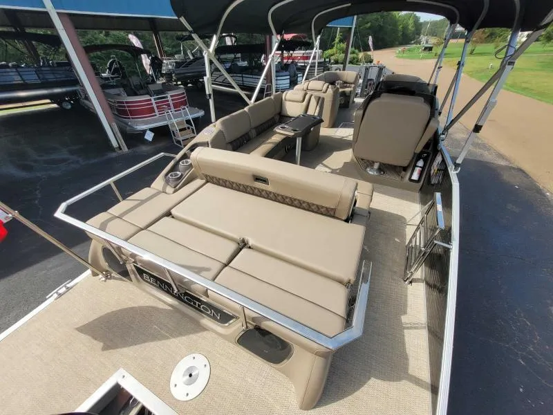 Slide: The Image of 2024 Bennington 25 RSB pontoon boat with spacious seating and canopy, displayed outdoors. - 10