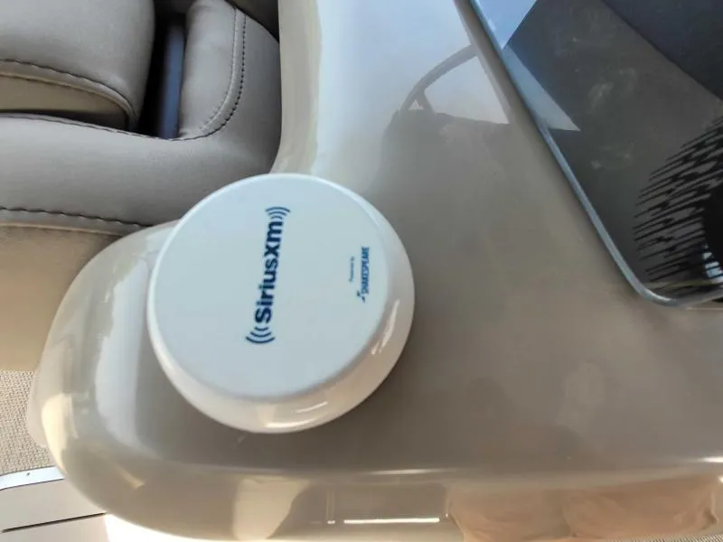 Slide: The Image of 2024 Bennington 25 RSB interior with SiriusXM receiver on beige surface. - 14